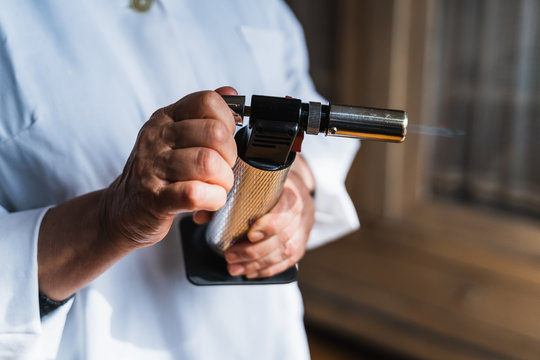 Cook using a kitchen torch with the flame coming out