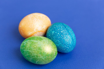 Beautiful multi-colored Easter eggs on a blue background. Religious tradition. Space for text.