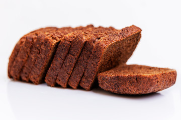 Sliced Russian Borodino brown bread on a white background. Healthy eating and traditions. Close-up.
