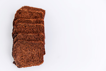Sliced Russian Borodino brown bread on a white background. Healthy eating and traditions. Close-up. Top view. Space for text.
