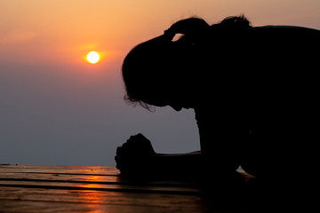 Silhouette of woman praying in the morning
