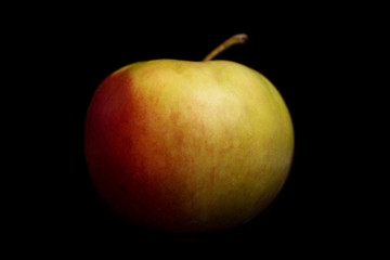 Juicy red apple. Black background. Healthy diet and vegan nutrition. Close-up.