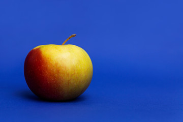 uicy red apple. Blue background. Healthy diet and vegan nutrition. Close-up.
