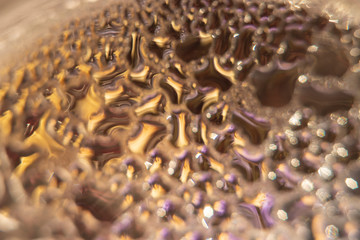 Blurred abstract background with large drops of water on a round glass surface under strong magnification.