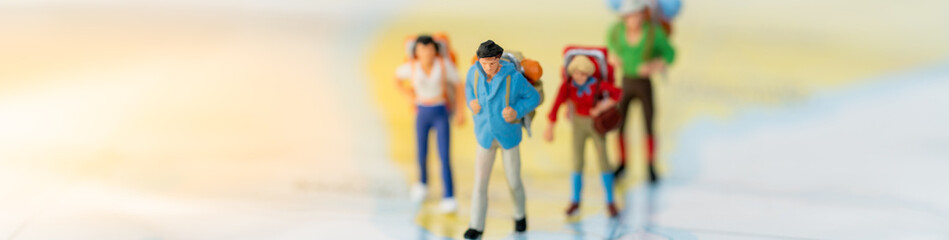 Miniature people: Group of backpacker on vintage world map using as background business trip traveler adviser agency or explorer on earth cover page concept.