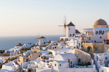Fototapeta premium Piękny widok na słynne romantyczne białe miasto Oia na wyspie Santorini, Grecja o zachodzie słońca