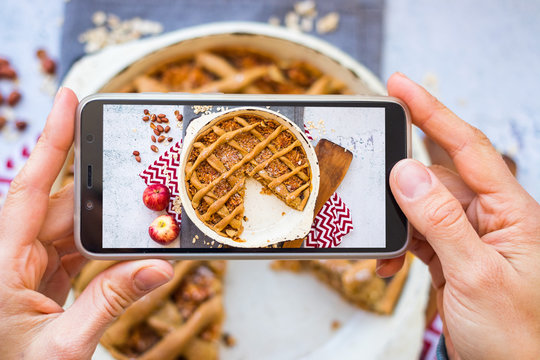 Make phone picture of food. Smartphone photo of apple pie dessert. Create blogging content. Vegan breakfast meal. Overhead.
