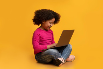 Modern Technologies For Kids. Black girl sitting with laptop on lap
