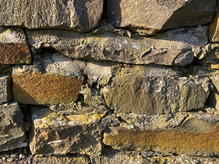 Rough, crumbling brick or rock wall. Background or wallpaper texture.