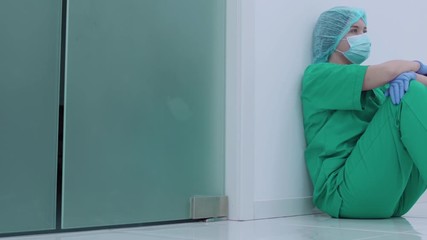 Exhausted surgeon sitting on the floor in clinic, stress at work, hopelessness