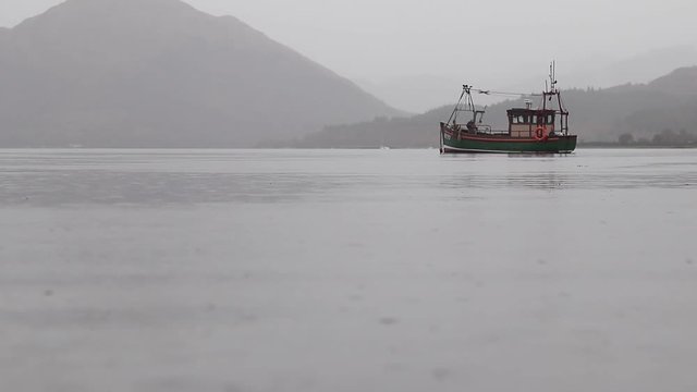 piccola imbarcazione peschereccio sotto la pioggia