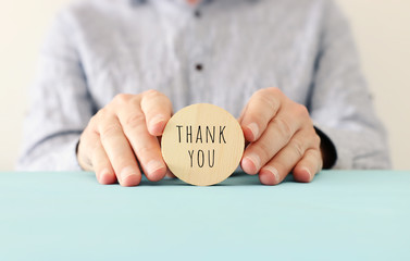 male hands holding sign with the text thank you