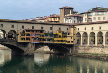 Fototapeta na wymiar Ponte Vecchio junto al rió Arno y sus remeros.