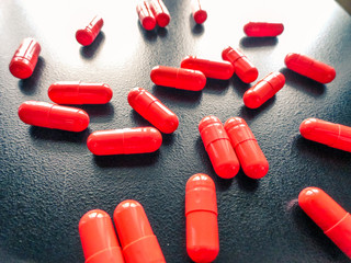 Photo of orange pills on a dark background.