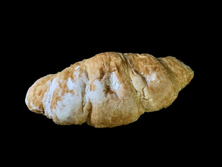 Tasty french croissant, on black background. Air pastries with cream filling inside. Bun for dessert with icing sugar.