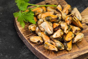 Mussel meat on wooden Board on dark background	