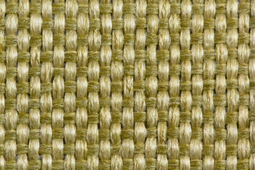 Abstract background from upholstery fabric guns for furniture in large knitting of golden, yellow threads in macro, empty template. Gunny. Large weaving of threads on the fabric.