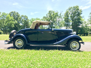 1934 Ford Roadster blue in park on green grass outdoor sky