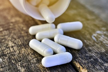 medicine capsules pouring out from bottle