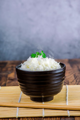 Cooked plain white basmati rice in terracotta bowl over plain background