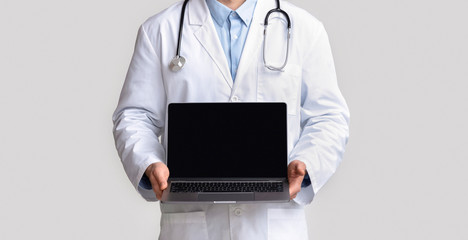 Doctor showing laptop with blank screen, empty space