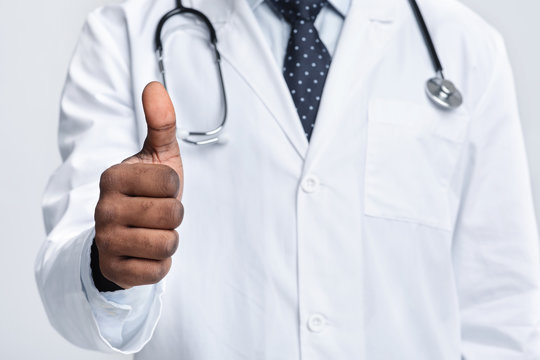 Cropped Of Medical Doctor Showing Thumbs Up Over White Background