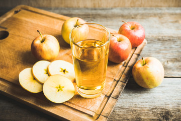 Apple juice with freshly harvested apples on the rustic background. Selective focus. Shallow depth of field.