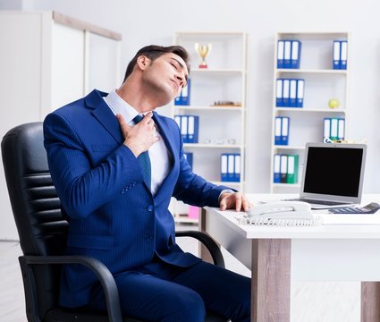Young businessman doing sports stretching at workplace