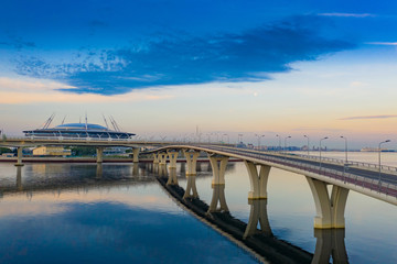Saint Petersburg. Russia. Bridge over Krestovsky island. Road Architecture of St. Petersburg. Large bypass bridge. A trestle over the bay. The bridge is reflected in the water. Russian roads