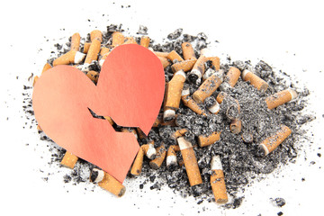 Cigarette butts and ashes are laid out in the shape of a heart. Image on the dangers of smoking