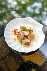 Scallop with tomatoes and sauce and basil