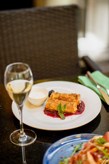 Thin pancakes with jam and glass of wine at terrace bokeh