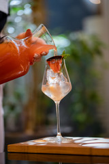 Waiter with Grapefruit lemonade and glasses on wooden board