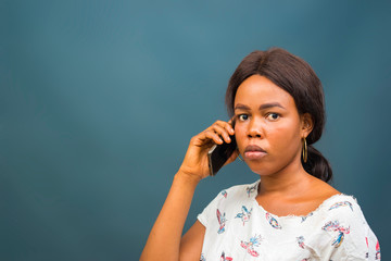 young beautiful african lady feeling disappointed about the call she is receiving with her smart...