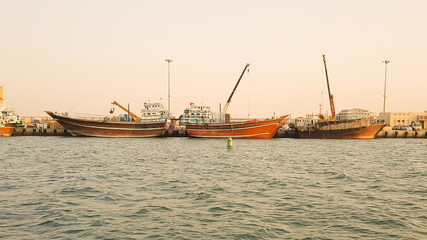 Obraz premium Boats on the harbor at sunset in Dubai