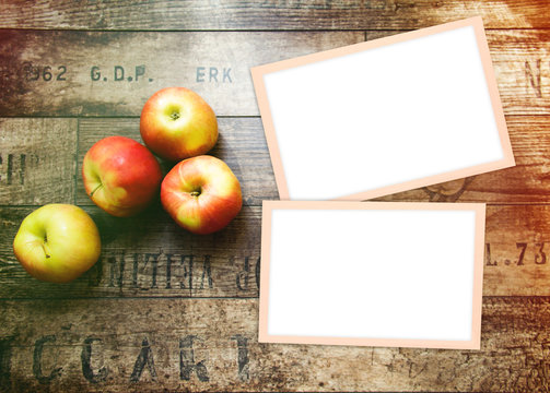 Home background with apples, white fotoframe and wood texture. Free space for your design and home interior