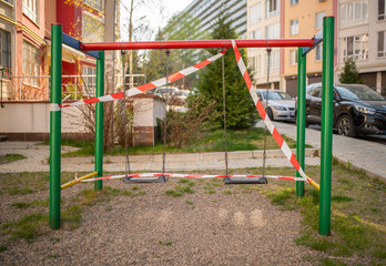 Fototapeta na wymiar Playground wrapped in striped red white tape, stay home. Quarantine area for sports, prevention of infection with the covid-19 coronavirus influenza virus