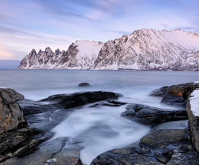 The rocky beach and frozen waves in pool on Ersfjord. Senja island in the Troms region of northern Norway. Long exposure shot