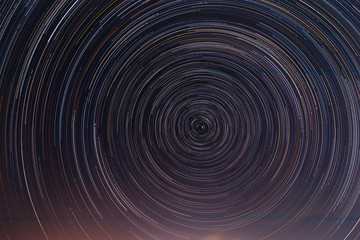 Stars track in the dark sky. Star trails orientation on the north star. Space background. Abstract long exposure background.