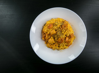 Classic valencian rice with seafood (Arroz a banda) - traditional dish of spanish cuisine on a dark wooden background.Top view.