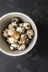 Quail eggs on a black background. Easter eggs. Dark photo