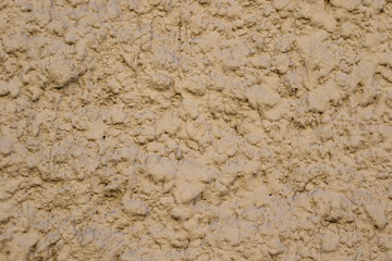 The texture of the concrete wall painted with yellow paint. Facade of the house