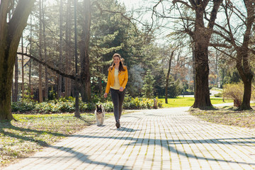 Beautiful girl walking her dog in park