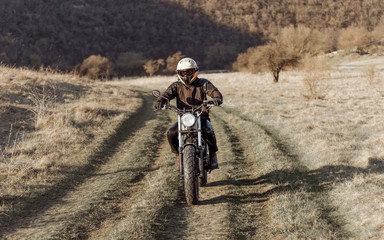 Horizontal view. Motorcyclist on desert, dry grass off road, extreme sport, active lifestyle, adventure touring concept, outdoor.