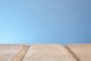Wooden surface on a blue lighted background in a blur. Photo from copy space.