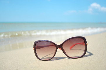 Fototapeta na wymiar woman sunglasses lying on the sea beach