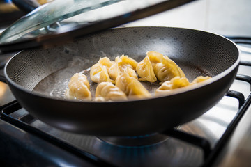 Chef Hand Cooking Chinese Potstickers Dumplings in a Pan