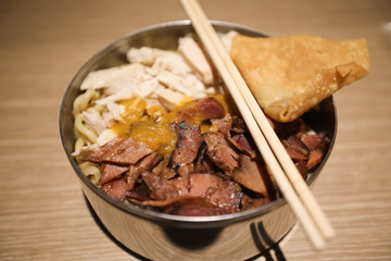 Closeup image of Indonesian food, Meat noodles, Bakmi, served on a bowl with chopstick