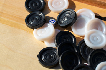 
dice with numbers and checkers to play board games on a wooden table