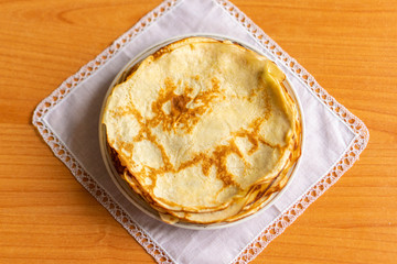 pancakes on a white tablecloth and plate a sunny day with sun glare